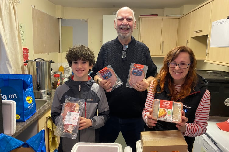 Graham Park and volunteers XX and XX handing out fresh meat and vegetarian food at Tavi Helps food hub.