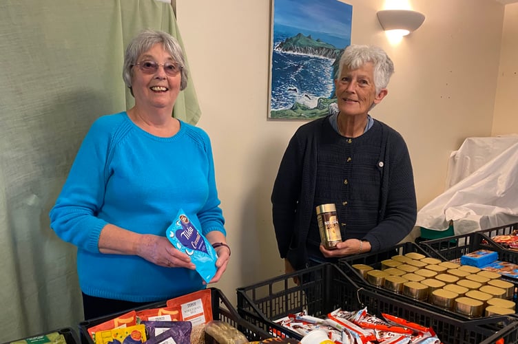 Tavy Helps volunteers XX and XX giving out non-perishable foods.