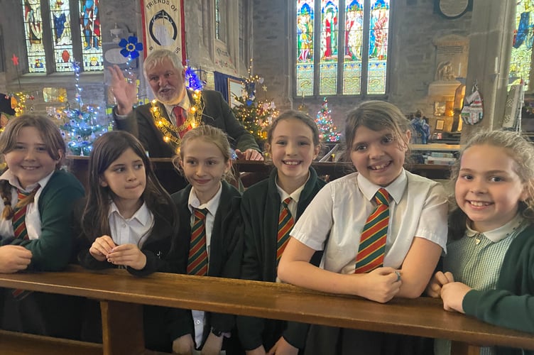 St Peter's Junior School choir from Tavistock sing their way through the launch of Tavistock Christmas Festival in St Eustachius' Church. Town Mayor Cllr Steve Hipsey applauds the singers.
