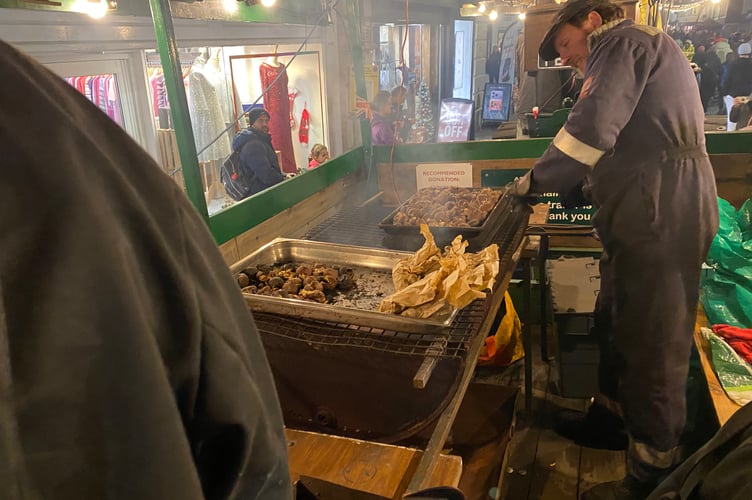 Tavistock Dickensian Evening - Robey Trust volunteers roast chestnuts on the hot coals on their steam engine.