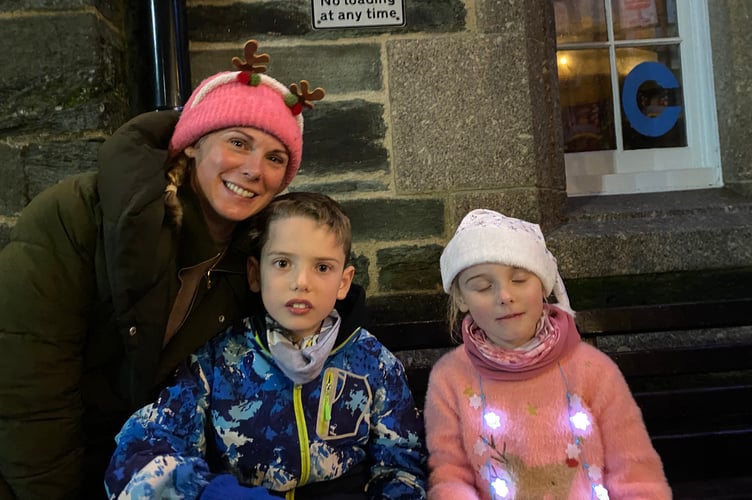 Tavistock Dickensian Evening - a mum takes time out from her refreshment stall to ensure to ensure her children are enjoying themselves.