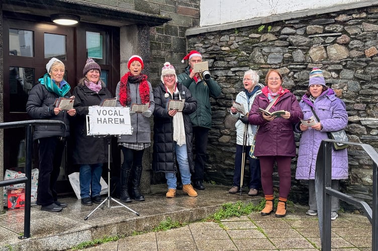 Some of Tavistock's Vocal Harem Choir singing carols, in Brook Street, Tavistock, for Christmas.