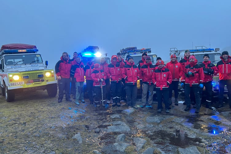 Members of the North Dartmoor Search and Rescue Team with retiring Land Rover Ada, far left, flanked by her replacement, on top of Yes Tor in wild winds on Sunday afternoon, December 7.