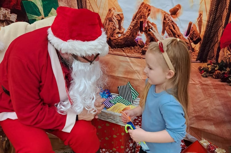 Sienna, of Sharman Class, meeting Santa at Bere Alston Primary.