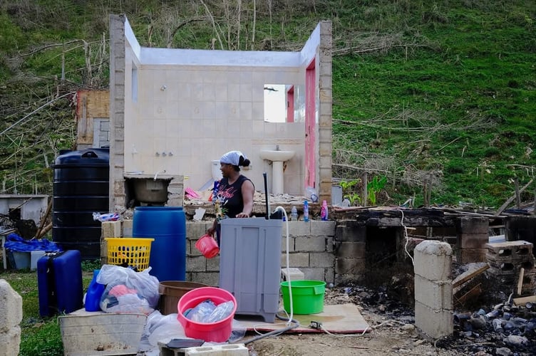 Charity volunteer humanitarian aid team worker Kirsten-Bailey Edmonds took this picture of a woman getting on with life in the ruins of her home amid the devastation of the Jamaica hurricane disaster.