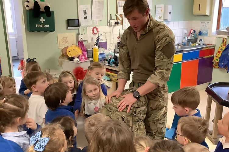 Army medic Liam Yeo shows the children his equipment