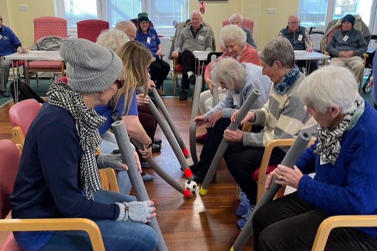 Tavistock Memory Cafe users enjoy a game of 'ice hockey' in their version of the Winter Olympics.