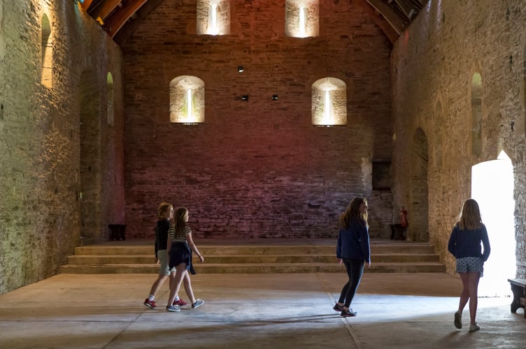 Visitors exploring the Great Barn at Buckland Abbey.