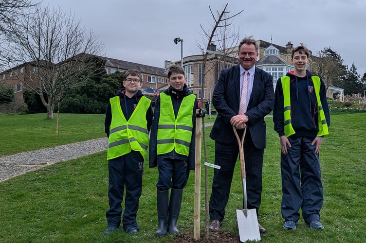 Headmaster Guy Ayling and pupils planting Japanese cherry trees at Mount Kelly Prep recently.