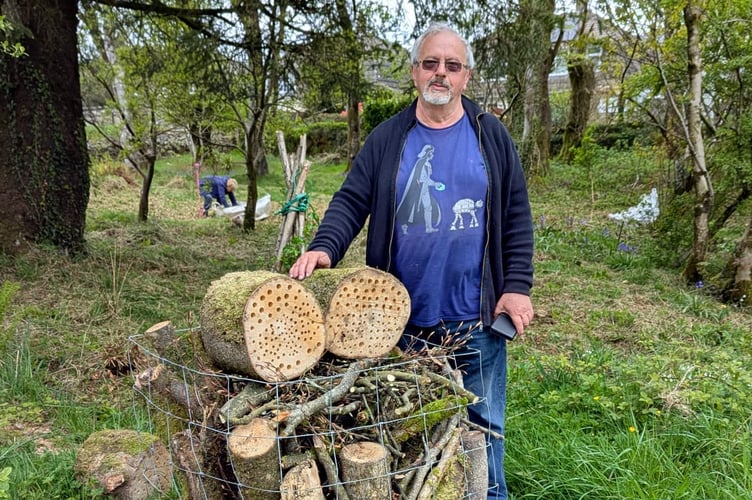 Princetown Churchyard Maintenance Group volunteer with a large bug 'hotel' which is designed to support insect life in the grounds.