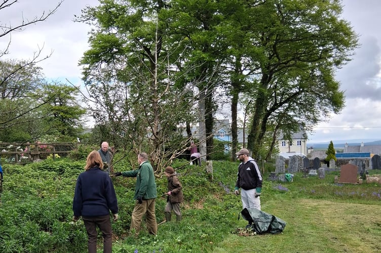 Princetown Churchyard Maintenance Group and Dartmoor Preservation Association volunteers clearing the grounds of weeds.