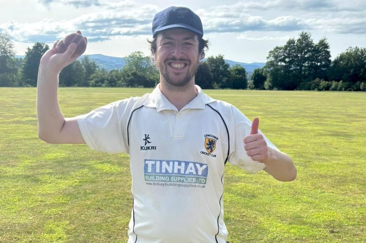 Lewdown's Nick Smith on the outfield at Stokeinteignhead with the match ball he took eight wickets with.