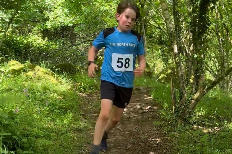 A young runner enjoying coping with the heat during the challenging Langstone Fell Race.