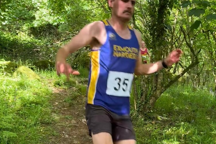 An Exmouth Harriers RC runner taking care on the downhill woodland track during the challenging Langstone Fell Race.