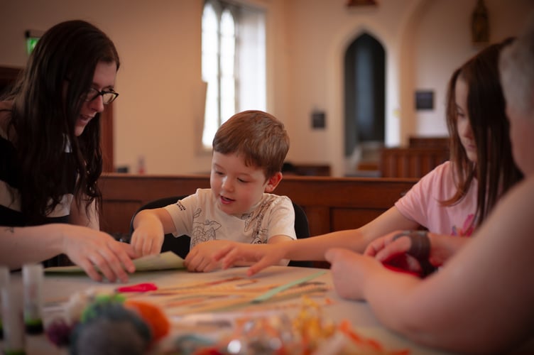 A creative family learning weaving using paper at the Tavistock Heritage Discovery half-term activity session in the Guildhall court house. Pictured are, from left mum Rebecca, Mylo, three, and Olivia, nine. Picture by Sam Griffith.