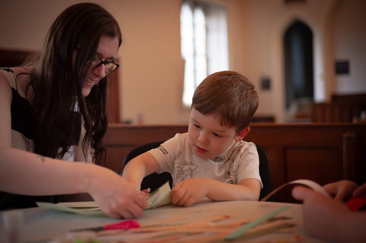 Mum Rebecca helps her son Mylo, 3, learn paper weaving during a Tavistock Heritage Trust half-term session in the Guildhall. Picture by Sam Griffith.