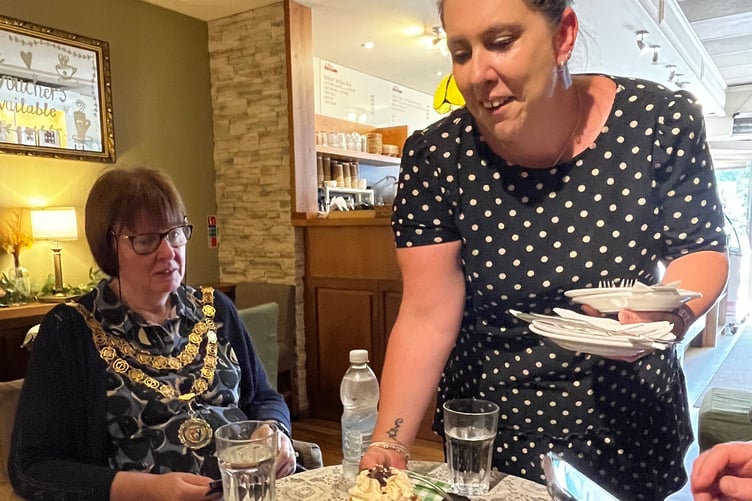 Tavistock Cream Tea Festival judge Mayor Cllr Anne Johnson is served her baked entry by town patisserie Coffee and Cream owner Lynda Wallace.