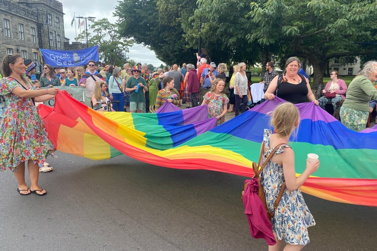 Flying a giant rainbow flag as the streets were lined with spectators to see a noisy, colourful and musical parade at TaviPride.