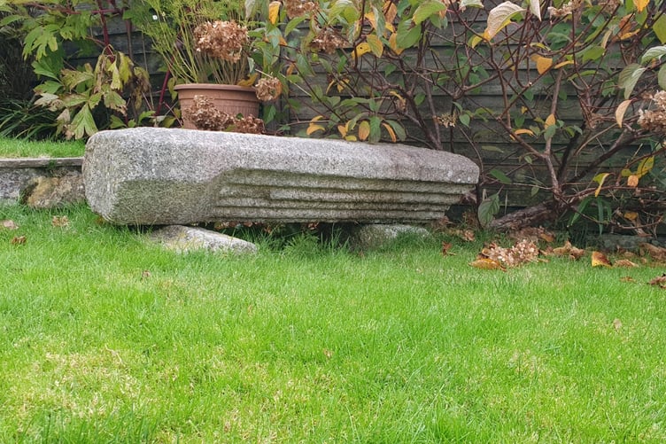 A large carved stone pillar from the former Tavistock Abbey is pictured on its side in a private garden in Tavistock.
