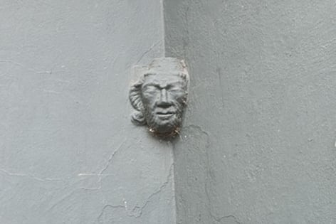 A carved stone human face, formerly from Tavistock Abbey, now appears to emerge out of a wall in one of the town's Co-op stores.