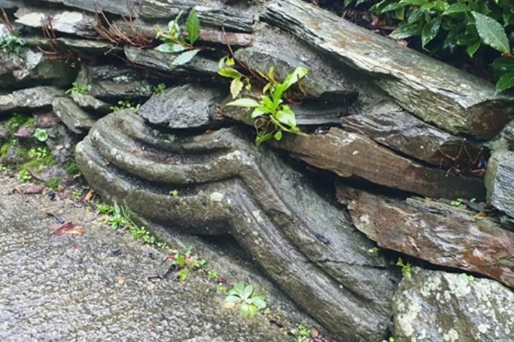 A piece of carved granite from the former Tavistock Abbey now forms part of a private garden wall on Watts Road.