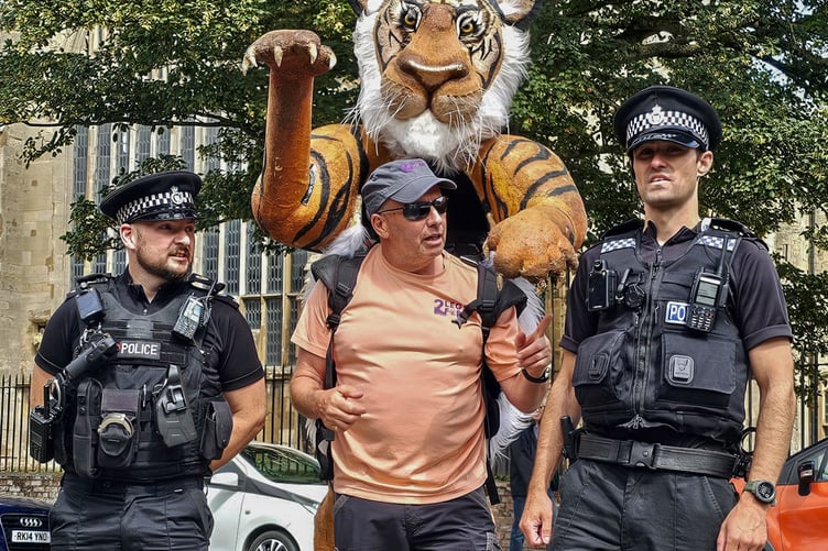 Paul Goldstein is stopping off in Tavistock on his 1,000-mile walk with a toy tiger strapped to his back in aid of tiger conservation. He is pictured earlier on his walk with some helpful police officers.