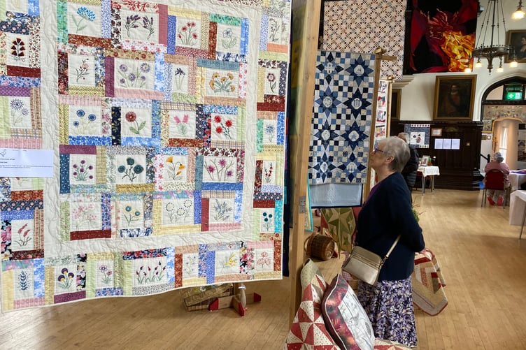 Visitors attracted by the creations of the Goosey Quilters at the community needleworkers' exhibition in Tavistock Town Hall.