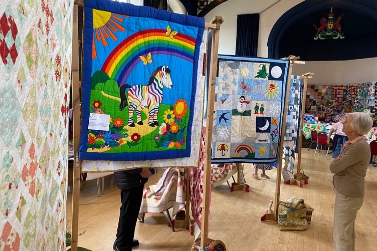 Visitors admire the colourful creations of the Goosey Quilters group at the community needleworkers' exhibition in Tavistock Town Hall.