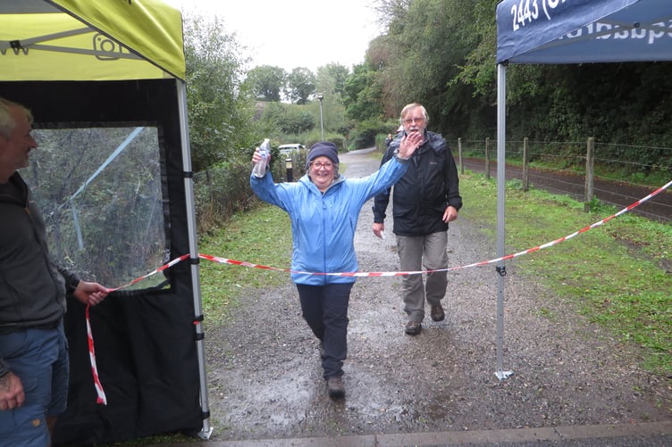 Crossing the finish line after a wet run.