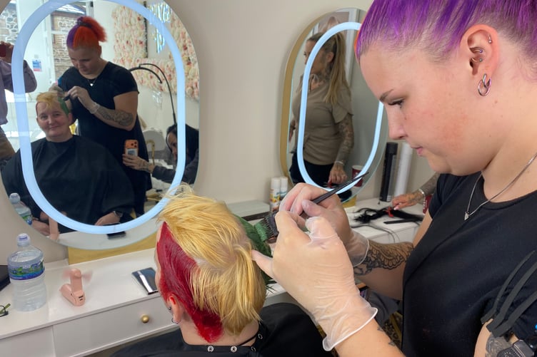 Jen Powers-Horn, seated, in Gypsy Glow beauty salon with stylist Nasha Wall on the right colouring her hair for charity.