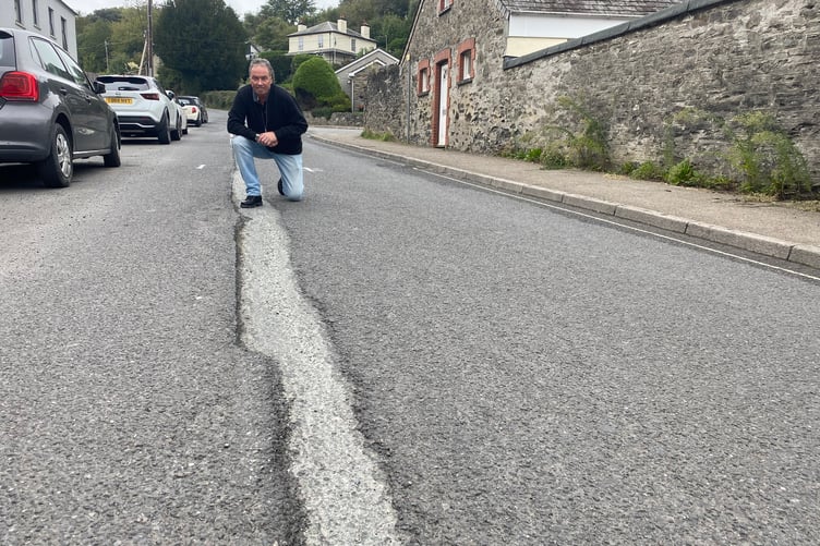 Drivers' champion Dave Newcombe marks four years of pothole campaigning in Tavistock. He is pictured at a blackspot on Butcher's Hill.