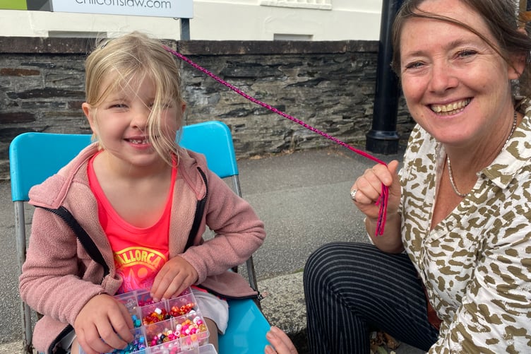 Evelyn Gray, 5, having her hair braided her favourite pink and purple at Tavistock Goose Fair.