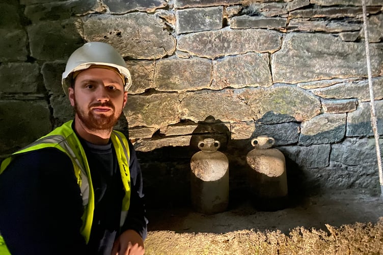 Stonemason Peter Cross is helping restore Betsy Grimbal's tower in Tavistock. He is pictured with some stone bottles uncovered on the ground floor.