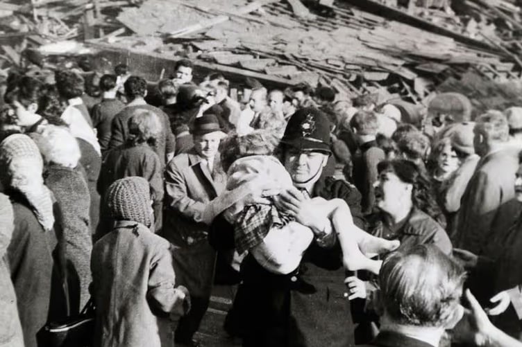 Policeman Victor Jones carrying injured survivor Susan Maybank from the rubble at Aberfan.