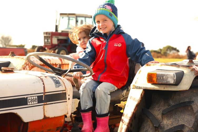 Two youngsters enjoy sitting in the hot seat of one of the many tractors in Fran Mudge's charity rally at Yelverton. Picture by Chris Cottrell.